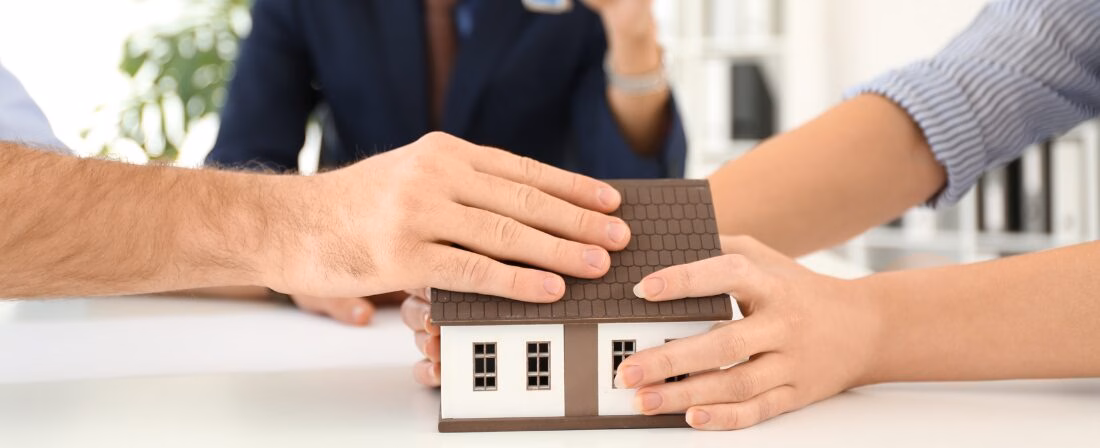 Varias personas con la maqueta de una casa