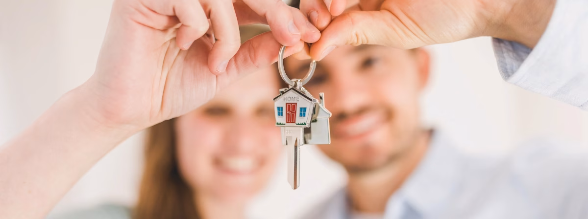 Una pareja sujetando las llaves de su nueva casa