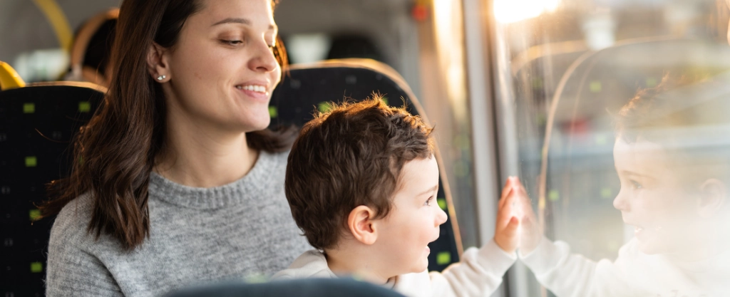 madre e hijo mirando por la ventanilla de un autobus 